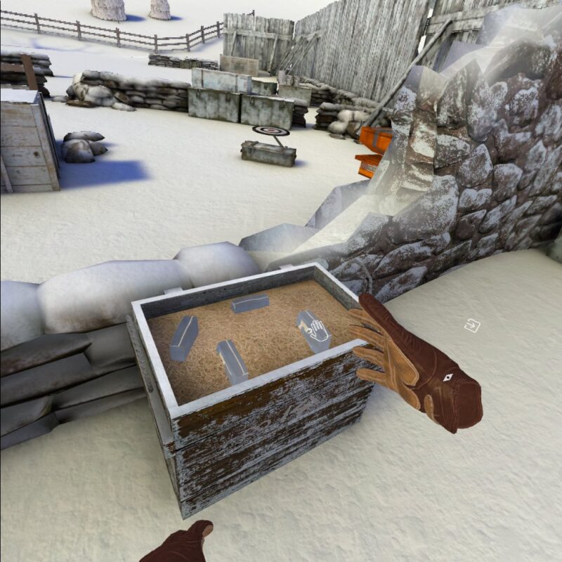 Gameplay of Winter Warrior showing the player examining a crate with objects in it. One object has a hand icon over it. There is also a small compass icon by the players right hand, and a square with an arrow pointing into it further to the right.