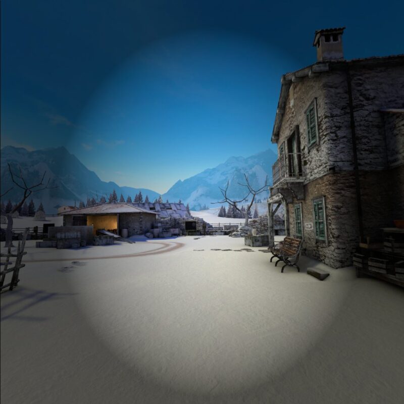 Gameplay of Winter Warrior with a vignette overlayed, which casts a semi-transparent darkness to the edges of the screen. Most of the scene is unaffected, showing a snowy courtyard with two distressed buildings, one to the right and one ahead. There are also leafless trees and many crates around the edges of the courtyard. In the distance coniferous trees can be seen, and beyond them large snowy mountains.