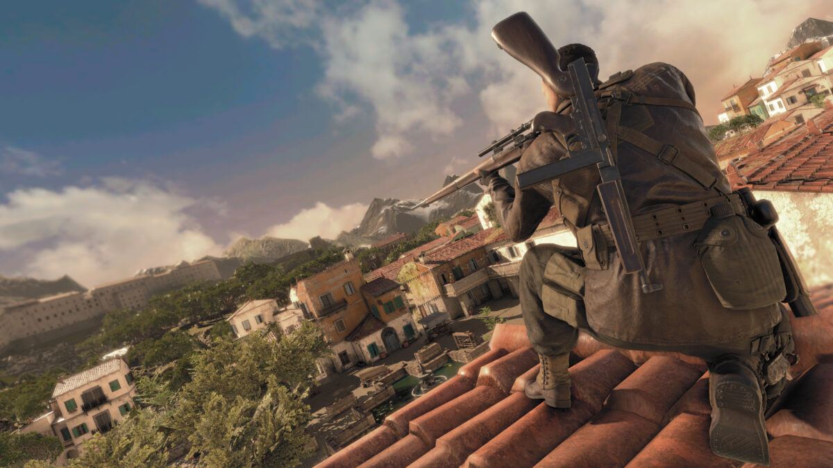 Karl Fairburne kneels on a rooftop, gazing down the scope of his sniper rifle. An SMG can be seen attached to his back. The scene in the background is of an Italian village in the day.