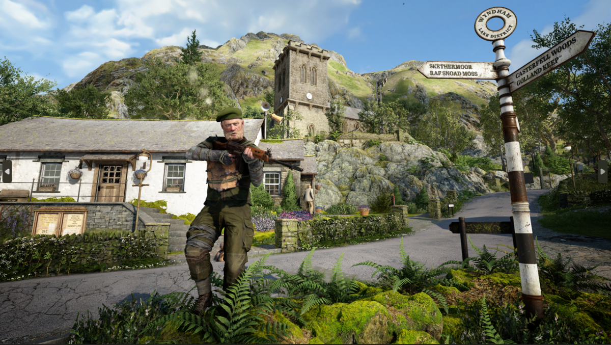 A Screenshot of a character holding a gun centred in the middle of the shot. Behind him is a wonderful British landscape, with a church and lots of other buildings and greenery. On the right is a sign reading "Wyndham Lake District".